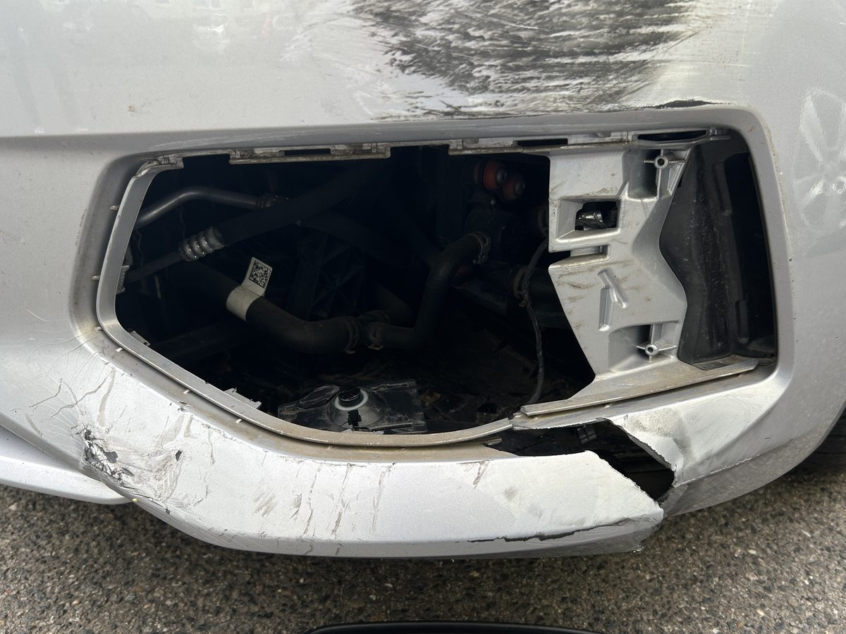 Aufgerissene vordere Stoßfängerecke eines silbernen Audi A6 Avant mit freiliegender Trägerverkleidung, Schadenhöhe 5.842,07 €
