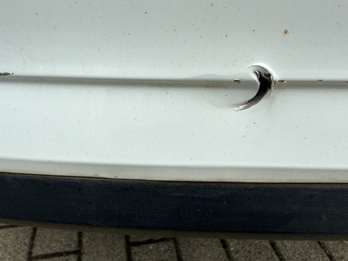 Falte in der weißen hinteren Stoßfängerschale eines Škoda Rapid, der Parksensor sitzt schief, Schadenhöhe 3.229,85 €